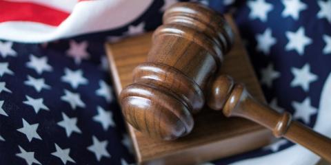 Wooden courtroom gavel sitting on American flag